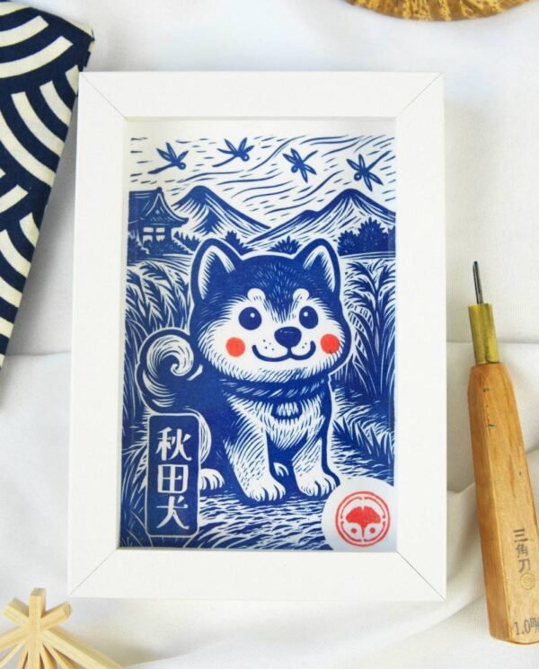 Linogravure en noir et blanc d’un chien Akita assis dans un champ, vu de trois quarts, avec des montagnes japonaises et des libellules en arrière-plan
