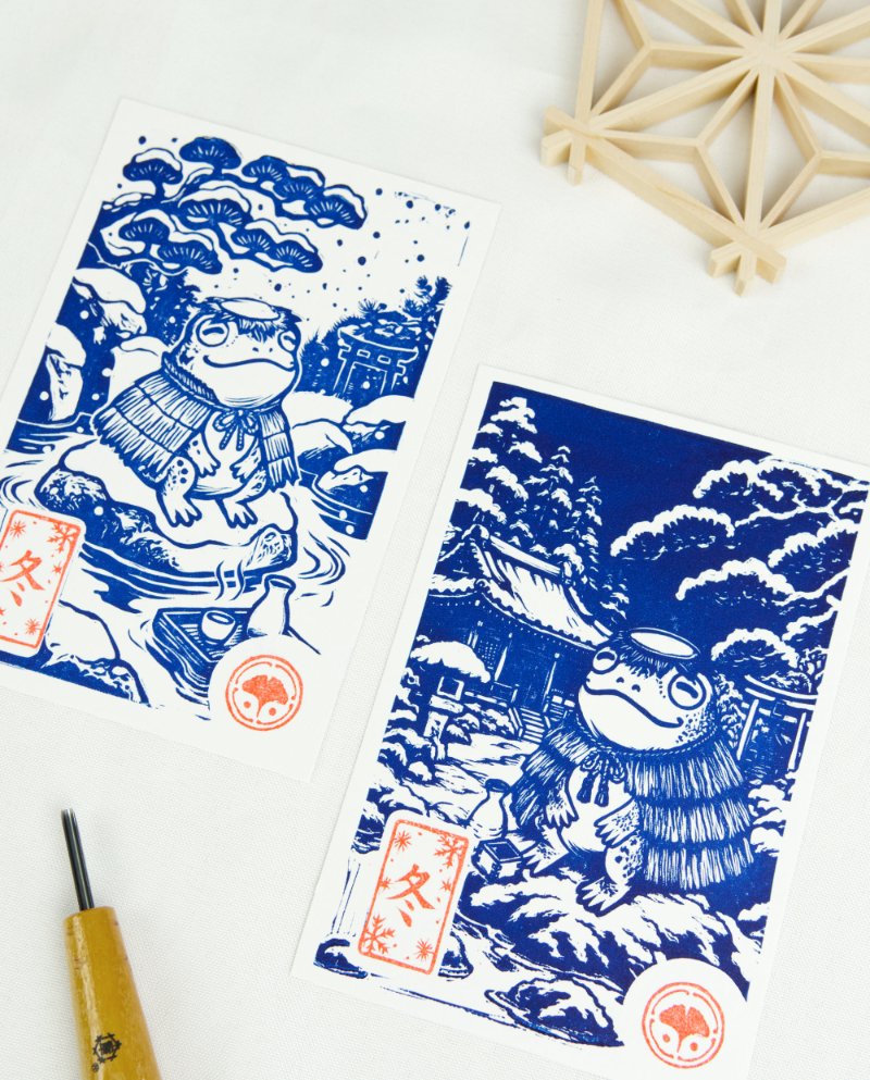 Estampes japonaises Yokai des saisons au format A6 : linogravures artisanales représentant un kappa, un tengu, un kitsune et un tanuki, imprimées à la main en noir, bleu et violet.