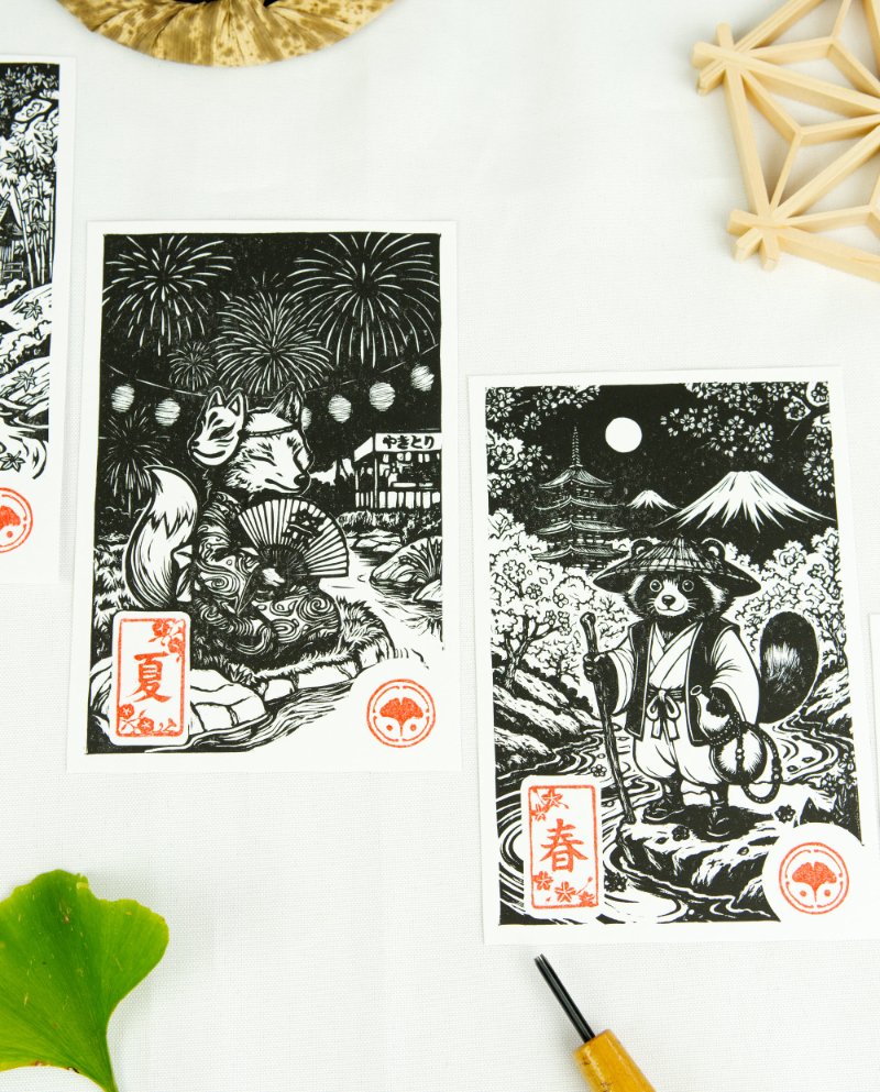 Estampes japonaises Yokai des saisons au format A6 : linogravures artisanales représentant un kappa, un tengu, un kitsune et un tanuki, imprimées à la main en noir, bleu et violet.