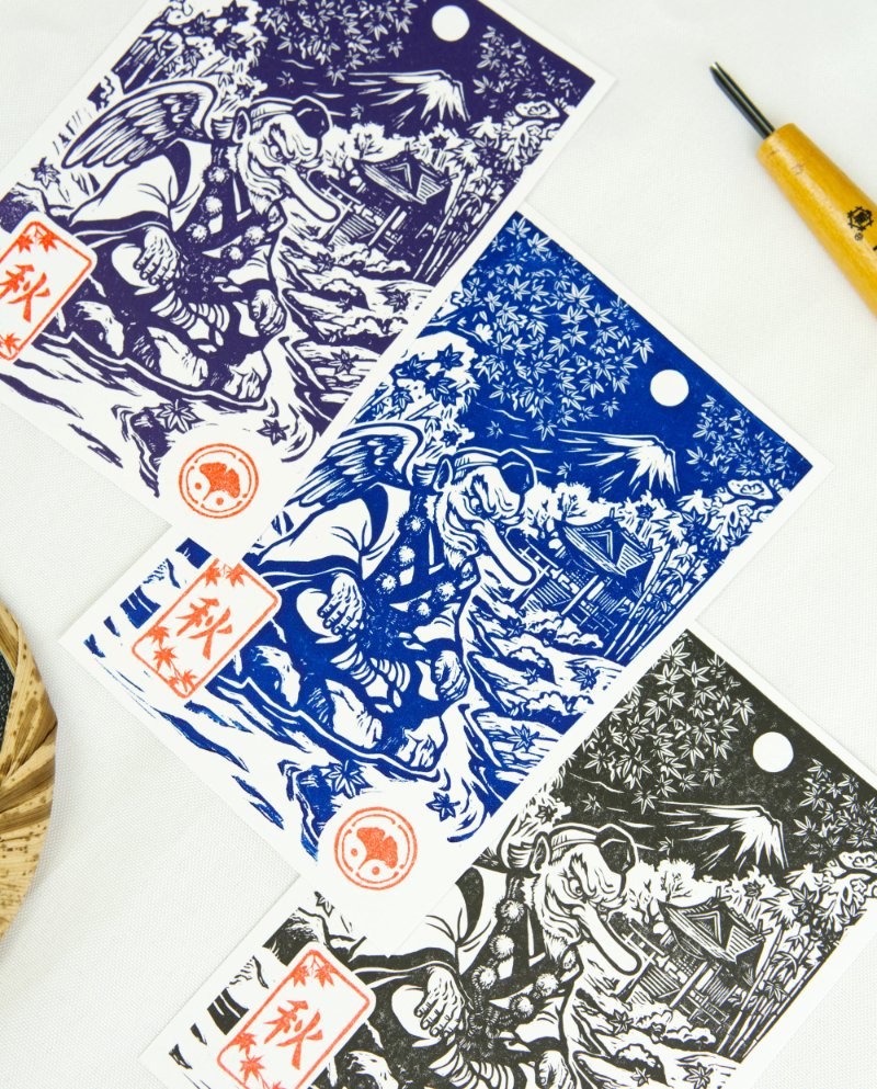 Estampes japonaises Yokai des saisons au format A6 : linogravures artisanales représentant un kappa, un tengu, un kitsune et un tanuki, imprimées à la main en noir, bleu et violet.